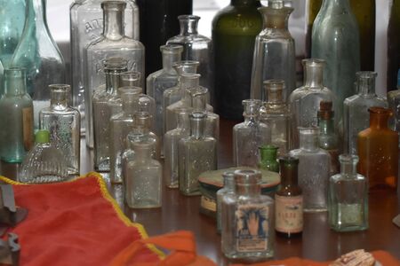 Many old and ancient vintage bottles stays on table with some blurの写真素材