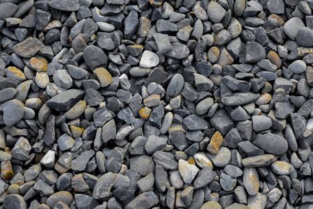 Gravel with small and medium size gray and dark yellow stones - backgroundの写真素材