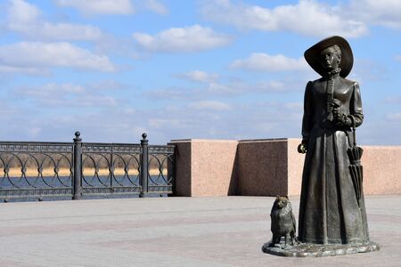 Bronze sculpture of women looks left with dog and umbrella on Volga river bankのeditorial素材