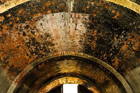 Window with bright light in the round tunnel from ancient bricksの写真素材