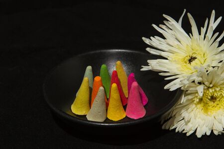 colorful incense cones in black bowlの写真素材
