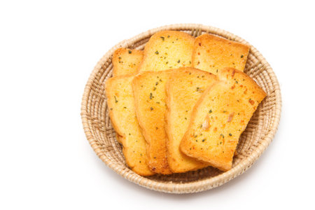 Crispy garlic bread in basket on white background