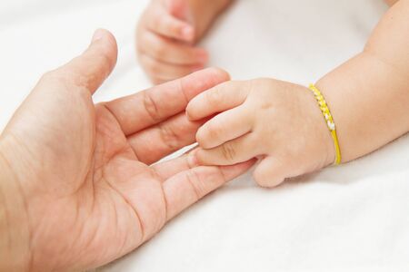 baby hand holding mother hand together,touch of happinessの写真素材