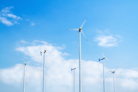 Many wind turbine generating electricity on blue skyの写真素材