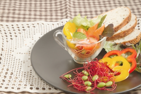 fresh vegetable salad in transparent bowl and whole wheat の写真素材