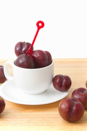 Red plum fruit in white cupの写真素材