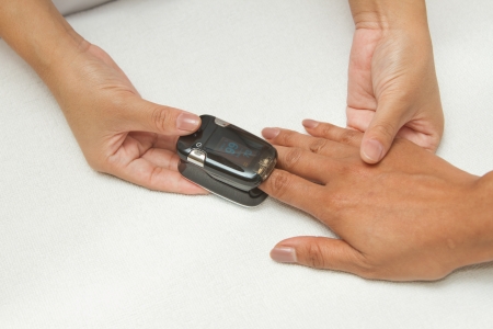 Patient with pulse oximeter on finger for monitoringの写真素材