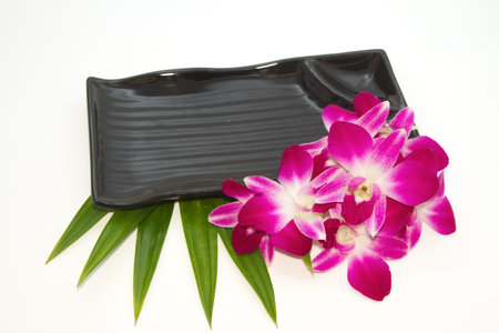Empty black plate with orchid の写真素材