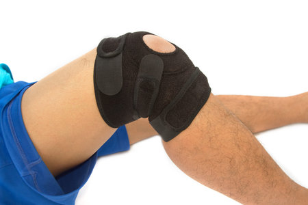 man legs with one knee in a protective knee brace