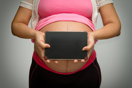 pregnant  woman holding tablet pcの写真素材