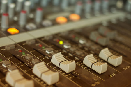 audio mixing console with faders and adjusting 