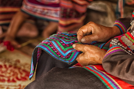 Female hand stitching cloth to make ancient Thai pattern fabricの写真素材