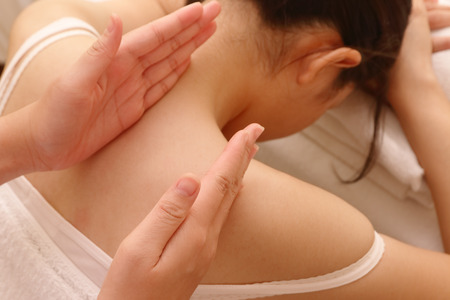 Close up of relaxing asian woman having massage on her neck and shoulderの写真素材
