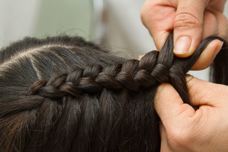 Hairdresser make braids in beauty salon