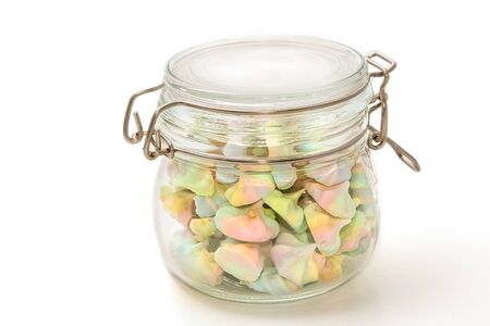 French rainbow meringue cookies in glass bowl on white backgroundの写真素材