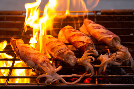 buttered fresh squid on flaming grillの写真素材