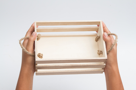 woman hands hold a empty wooden crate on white backgroundの写真素材