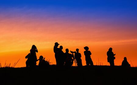 Silhouette tourists and photographers with beautiful sunrise on mountainの写真素材