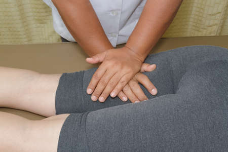 Physical therapist doing massage on woman's legの写真素材