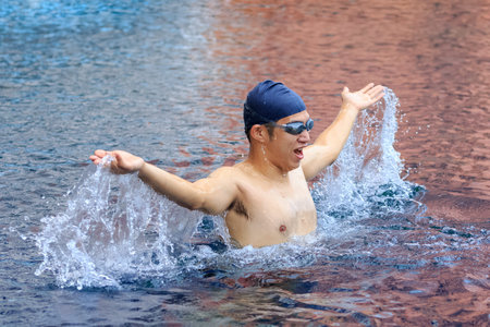 Man swimming cheering celebrating victory success smiling happy in pool.