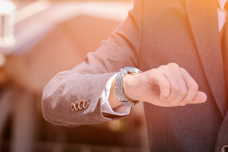 Handsome businessman looking at his watchの写真素材