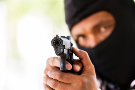 Man with gun, gangster, focus on the gun (robbery, gun, pistol)の写真素材