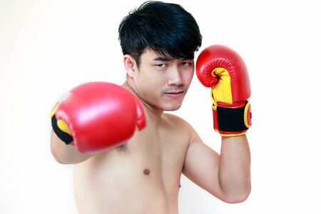 Handsome muscular young man wearing boxing glovesの写真素材
