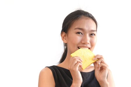 Portrait of young woman eating slice of breadの写真素材