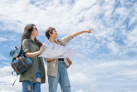 Tourist couple using a map for find location under blue skyの写真素材