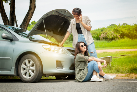 Woman calling the roadside service/assistance after her car has broken downの写真素材
