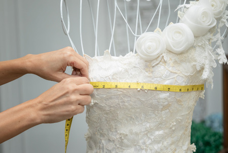 dressmaker designer working with mannequin in wedding dressの写真素材