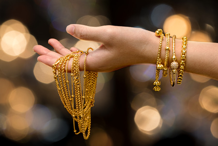 woman hand hold gold bracelet and necklace  jewelryの写真素材