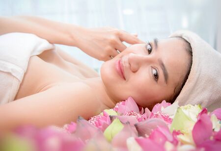 Happy relax woman in spa salon lying on the massage deskの写真素材