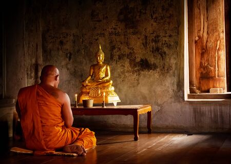 Buddhist monk pray to buddha in the templeの写真素材