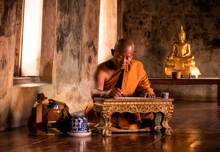 Buddhist monk reading book in the ancient churchの写真素材