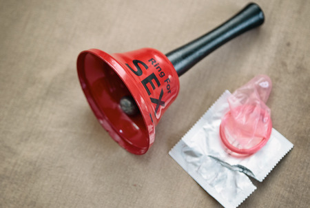 Safety sex and contraception, sex bell with condom on bed の写真素材