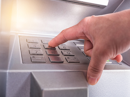 Closeup of hand entering PIN/pass code on bank machine keypadの写真素材