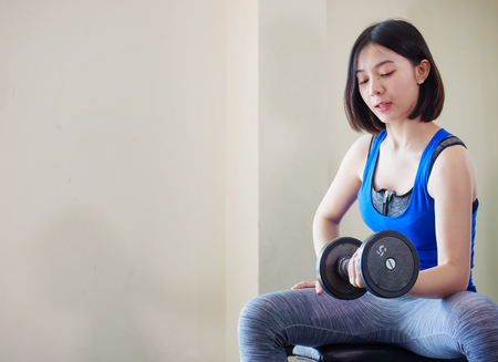 Young Asian woman training weight lifting at gym, の写真素材