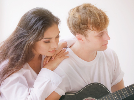 Couple in love playing acoustic guitar in the homeの写真素材
