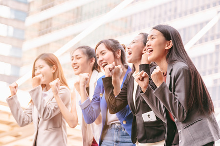 Group of businesswomen team success achievement with arm raised to celebrating good job.の写真素材