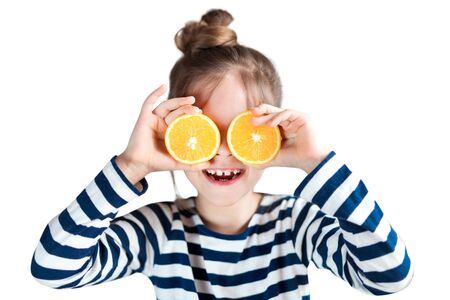 Girl with oranges on the background in the studioの写真素材