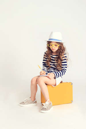 Girl with a notebook and suitcaseの写真素材