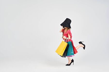 Busy girl in oversized high heels and with shoppers bagsの写真素材