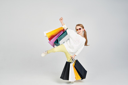 Girl in a pose with shoppers bagsの写真素材