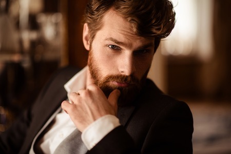 Close up portrait of confident businessman has thick ginger beard and mustache, dressed formally, being self assured in his success, waits for business partner. People, work, job, occupation conceptの写真素材