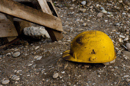 Dirty old work helmet left on the ground of construction site