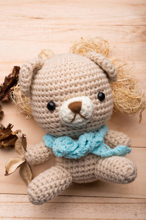 Knitted teddy bear on wood backgroundの写真素材