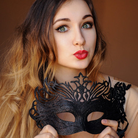 attractive mysterious elegant young girl with black mask eveningの写真素材