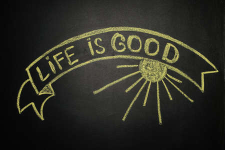 Life is good with Ribbon Banner, written with yellow chalk on a blackboardの写真素材
