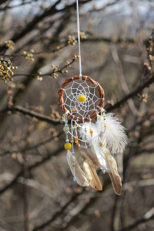 Handmade native american dream catcher on background of rocks and lake. Tribal elements, feathersの写真素材